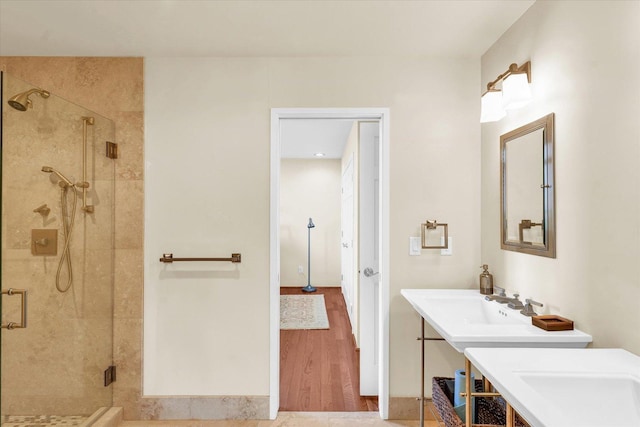 bathroom featuring a sink, wood finished floors, and a shower stall