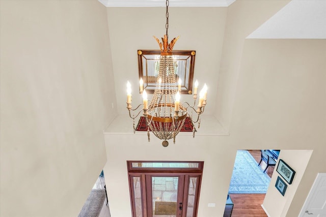 details featuring a chandelier, ornamental molding, and wood finished floors