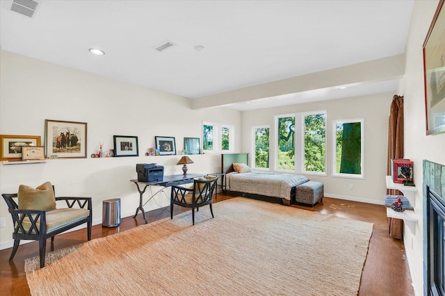 bedroom featuring a fireplace with flush hearth, multiple windows, baseboards, and visible vents