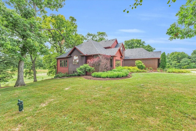 view of front of house with brick siding, roof with shingles, and a front yard