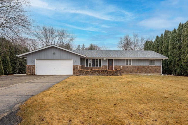 ranch-style house featuring a front yard, a shingled roof, a garage, aphalt driveway, and brick siding