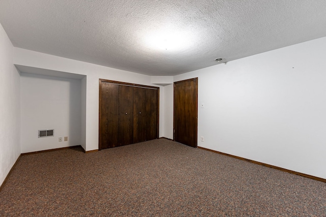 unfurnished bedroom featuring visible vents, baseboards, carpet flooring, a closet, and a textured ceiling