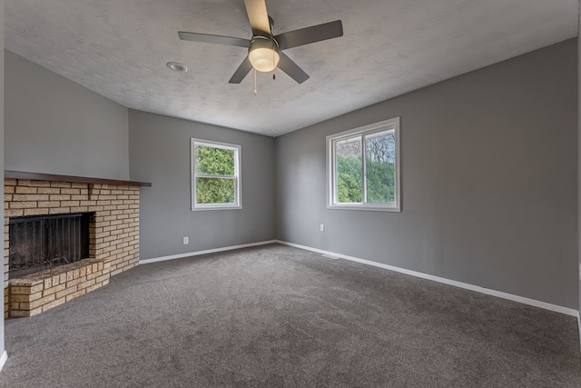 unfurnished living room featuring a fireplace, baseboards, carpet floors, and a textured ceiling