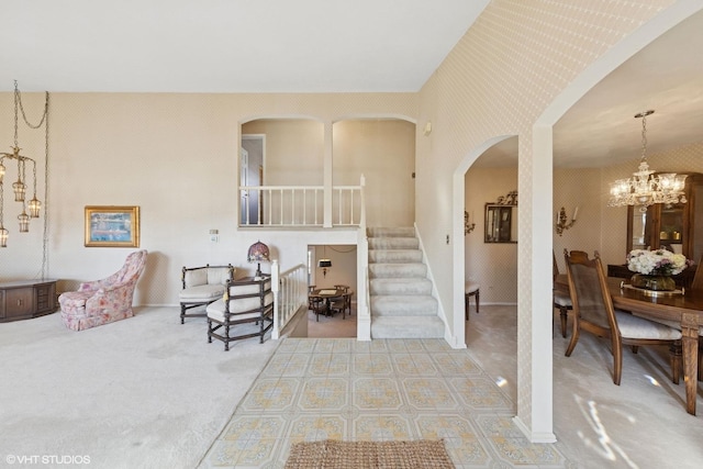 interior space with stairway, a notable chandelier, and wallpapered walls