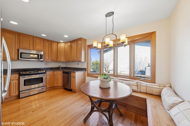 kitchen featuring light wood-style flooring, decorative light fixtures, recessed lighting, stainless steel appliances, and a chandelier