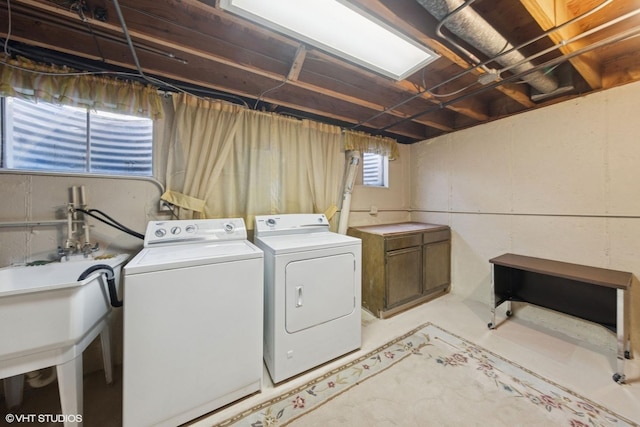 clothes washing area with independent washer and dryer and a sink