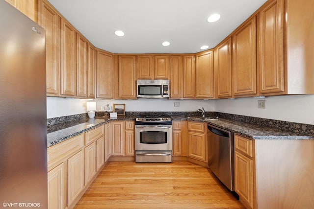 kitchen featuring a sink, stainless steel appliances, recessed lighting, and light wood finished floors