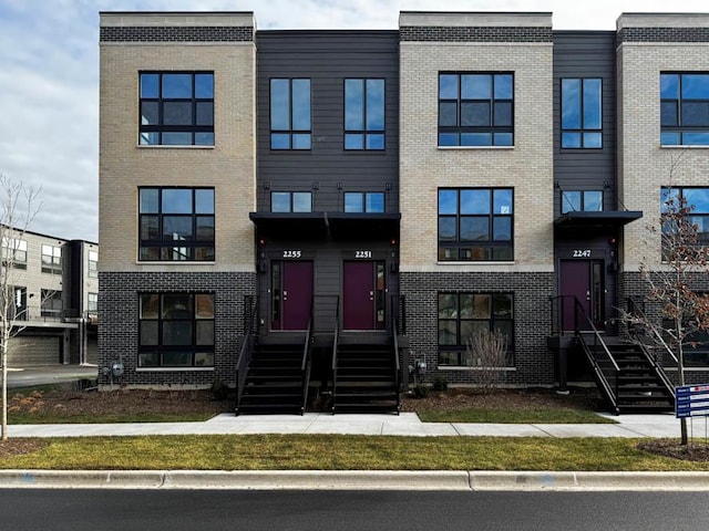 townhome / multi-family property with brick siding and entry steps