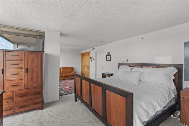 bedroom featuring visible vents, light colored carpet, and a textured ceiling