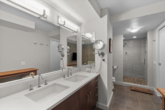 full bath featuring a sink, toilet, a stall shower, and tile patterned floors