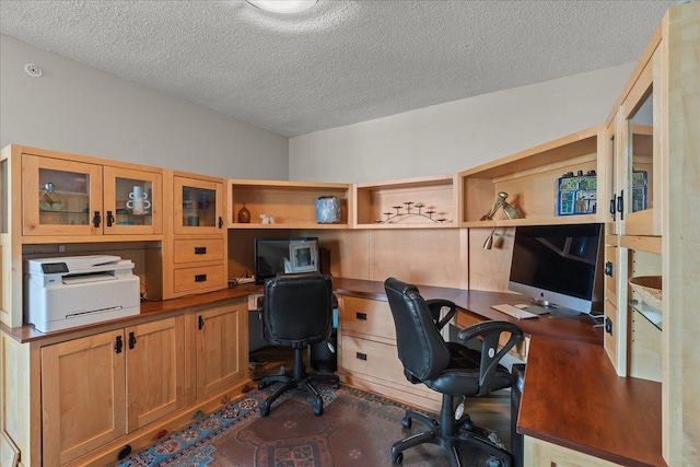 office featuring built in desk and a textured ceiling