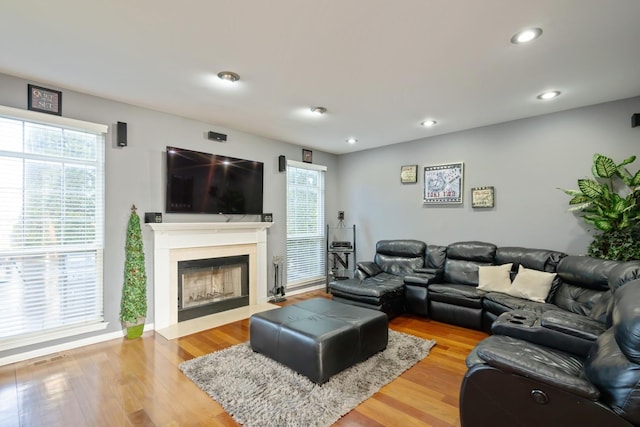 living area with plenty of natural light, light wood-style floors, and a fireplace with flush hearth