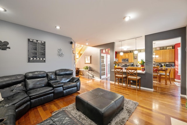 living room with stairs, light wood-style flooring, and recessed lighting