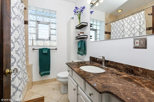 full bathroom featuring a shower with shower curtain, a healthy amount of sunlight, toilet, and vanity