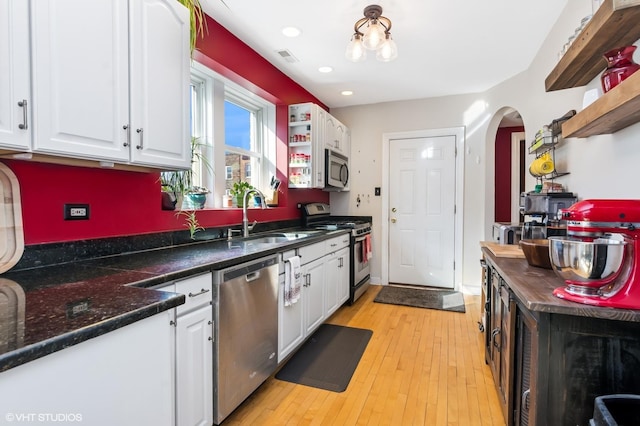 kitchen featuring open shelves, appliances with stainless steel finishes, white cabinets, and a sink