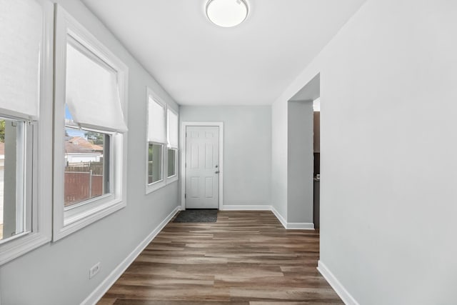 hall featuring baseboards and wood finished floors