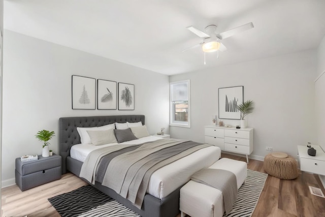 bedroom with a ceiling fan, baseboards, and light wood finished floors