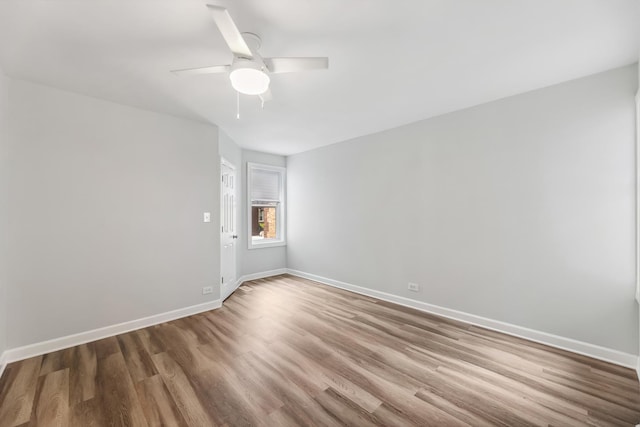 unfurnished room with ceiling fan, baseboards, and wood finished floors