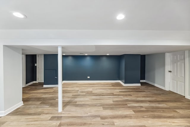 finished below grade area featuring recessed lighting, baseboards, and light wood finished floors