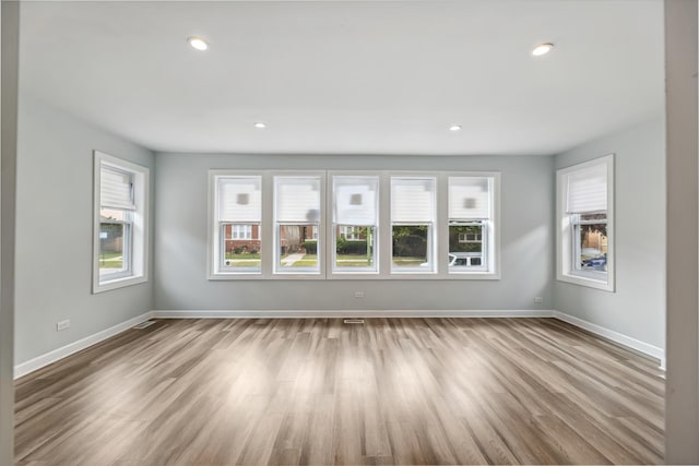 empty room featuring recessed lighting, baseboards, and wood finished floors