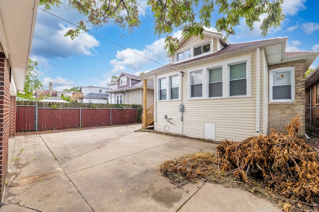 view of property exterior with a patio and fence