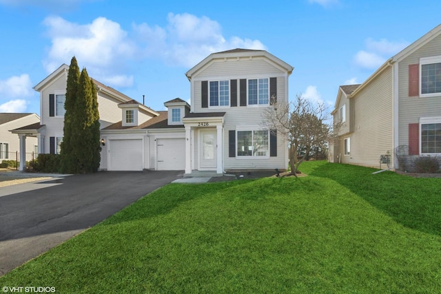 view of front of property featuring a front yard, an attached garage, and driveway