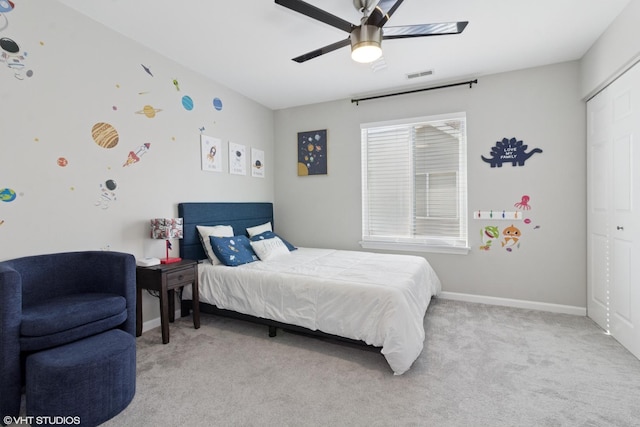 carpeted bedroom with a closet, visible vents, ceiling fan, and baseboards