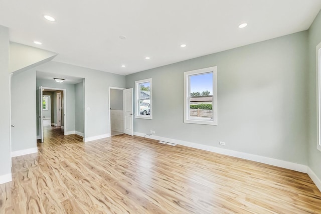 empty room with light wood-style flooring, recessed lighting, and baseboards