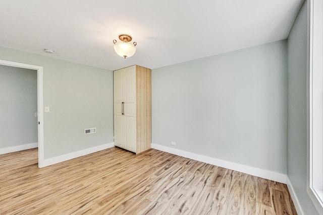 unfurnished bedroom featuring visible vents, light wood-type flooring, and baseboards