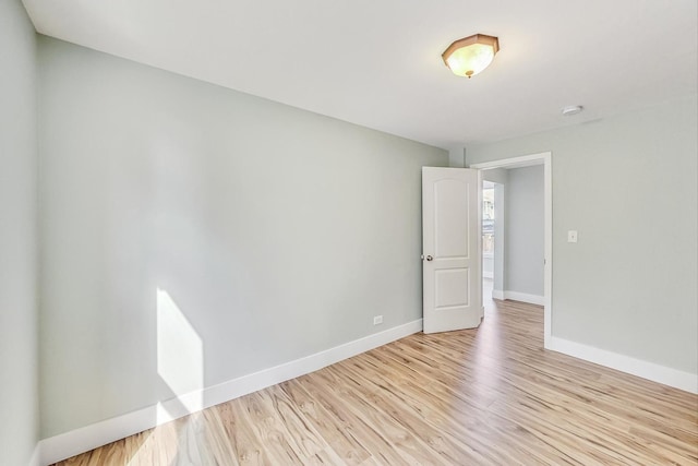 unfurnished room with baseboards and light wood-style floors