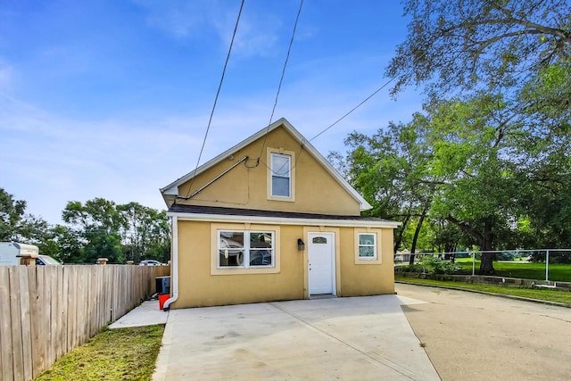 bungalow featuring a patio, a fenced backyard, roof with shingles, and stucco siding