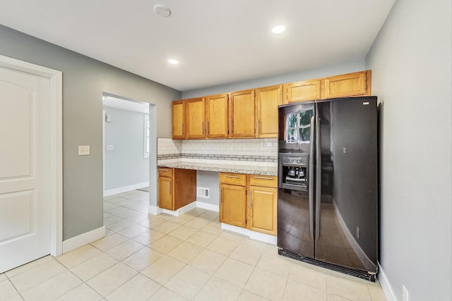 kitchen with black fridge, recessed lighting, light tile patterned floors, decorative backsplash, and baseboards