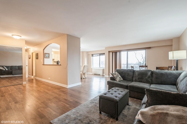 living area with baseboards and wood finished floors