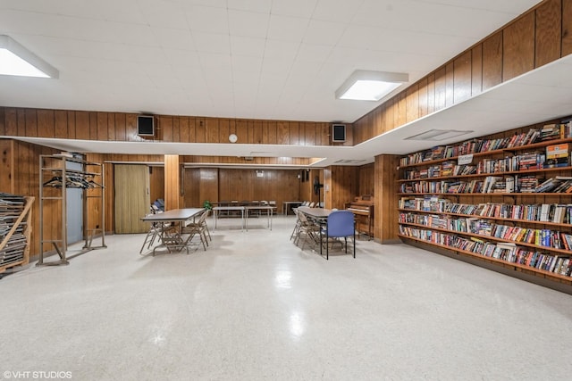 unfurnished room with wood walls and bookshelves