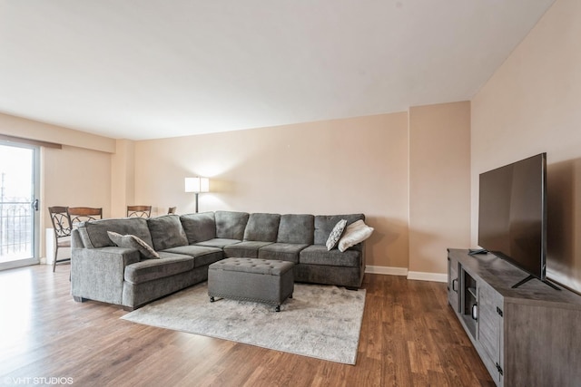 living room featuring baseboards and dark wood-style flooring