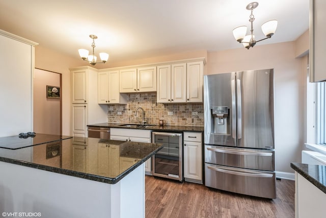 kitchen featuring dark wood-type flooring, beverage cooler, a sink, appliances with stainless steel finishes, and an inviting chandelier