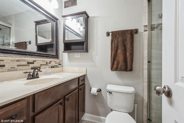 bathroom featuring visible vents, toilet, a shower stall, decorative backsplash, and vanity