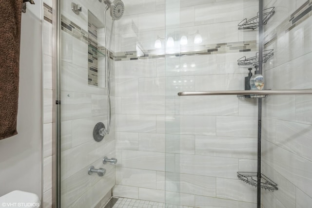 full bath with toilet and tiled shower