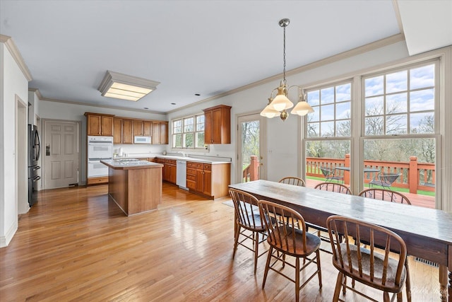dining area with ornamental molding and light wood finished floors
