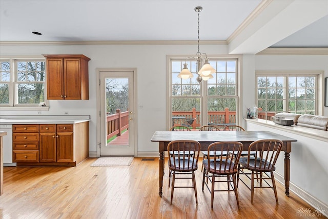 dining space with visible vents, baseboards, an inviting chandelier, ornamental molding, and light wood-style flooring