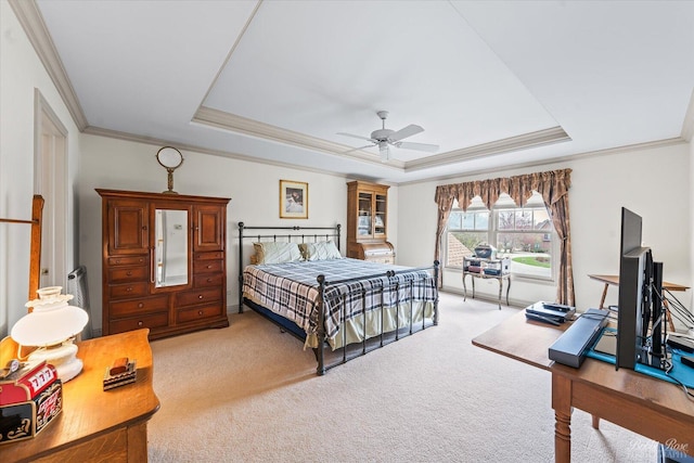bedroom featuring ceiling fan, light colored carpet, ornamental molding, and a raised ceiling