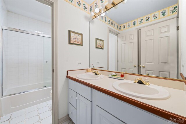 full bathroom with a sink, tile patterned floors, double vanity, and enclosed tub / shower combo