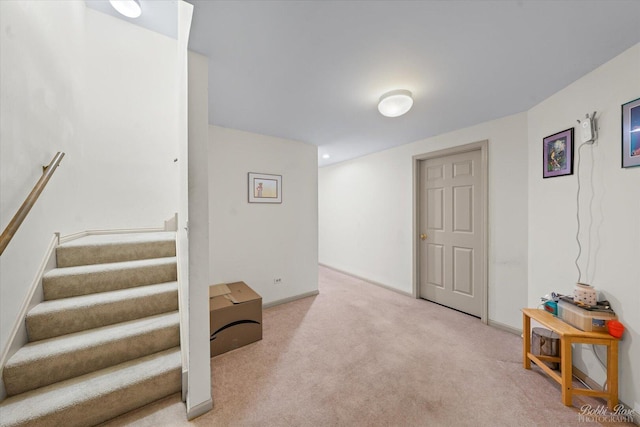 basement with carpet floors, baseboards, and stairs