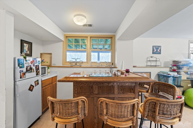 interior space with bar area, white appliances, and visible vents