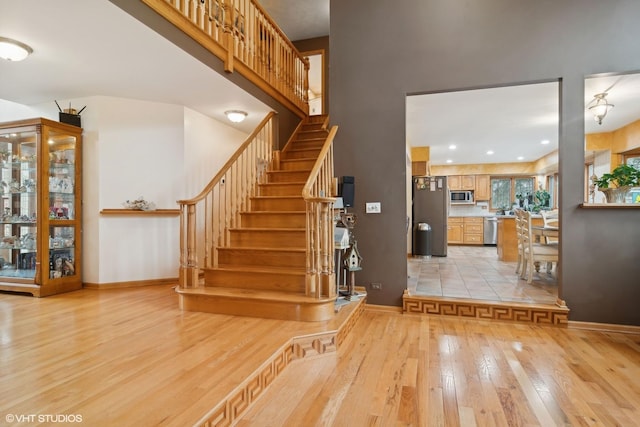 staircase featuring recessed lighting, baseboards, and wood-type flooring