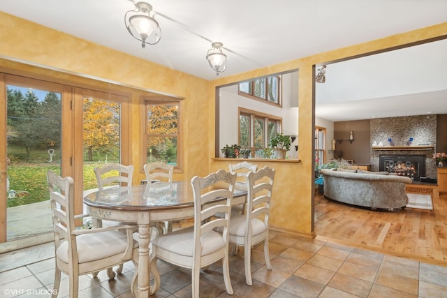 tiled dining area featuring a large fireplace