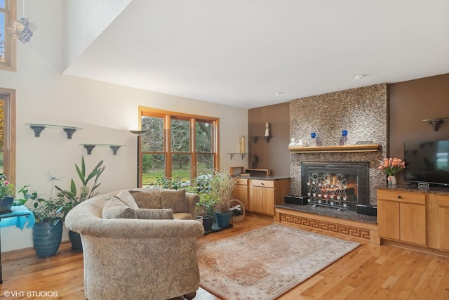 living room with light wood-style floors and a large fireplace