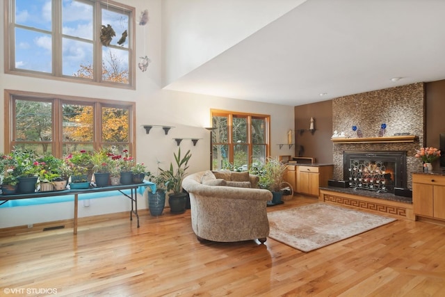 living room with a wealth of natural light, light wood-style floors, and a fireplace