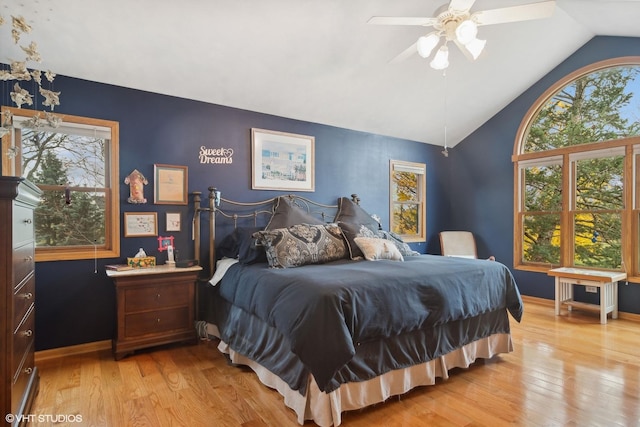 bedroom with lofted ceiling, multiple windows, and light wood-type flooring