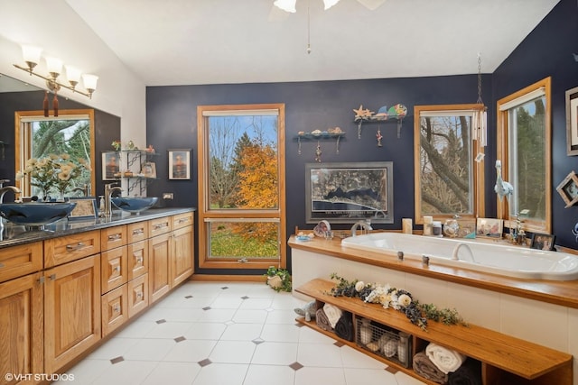 bathroom with lofted ceiling, a garden tub, double vanity, and a sink